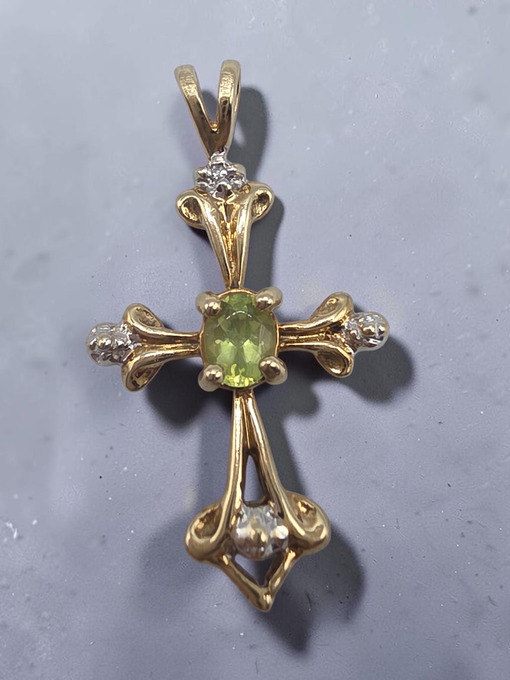 Solid 10K yellow gold oval peridot cross pendant with diamond accent