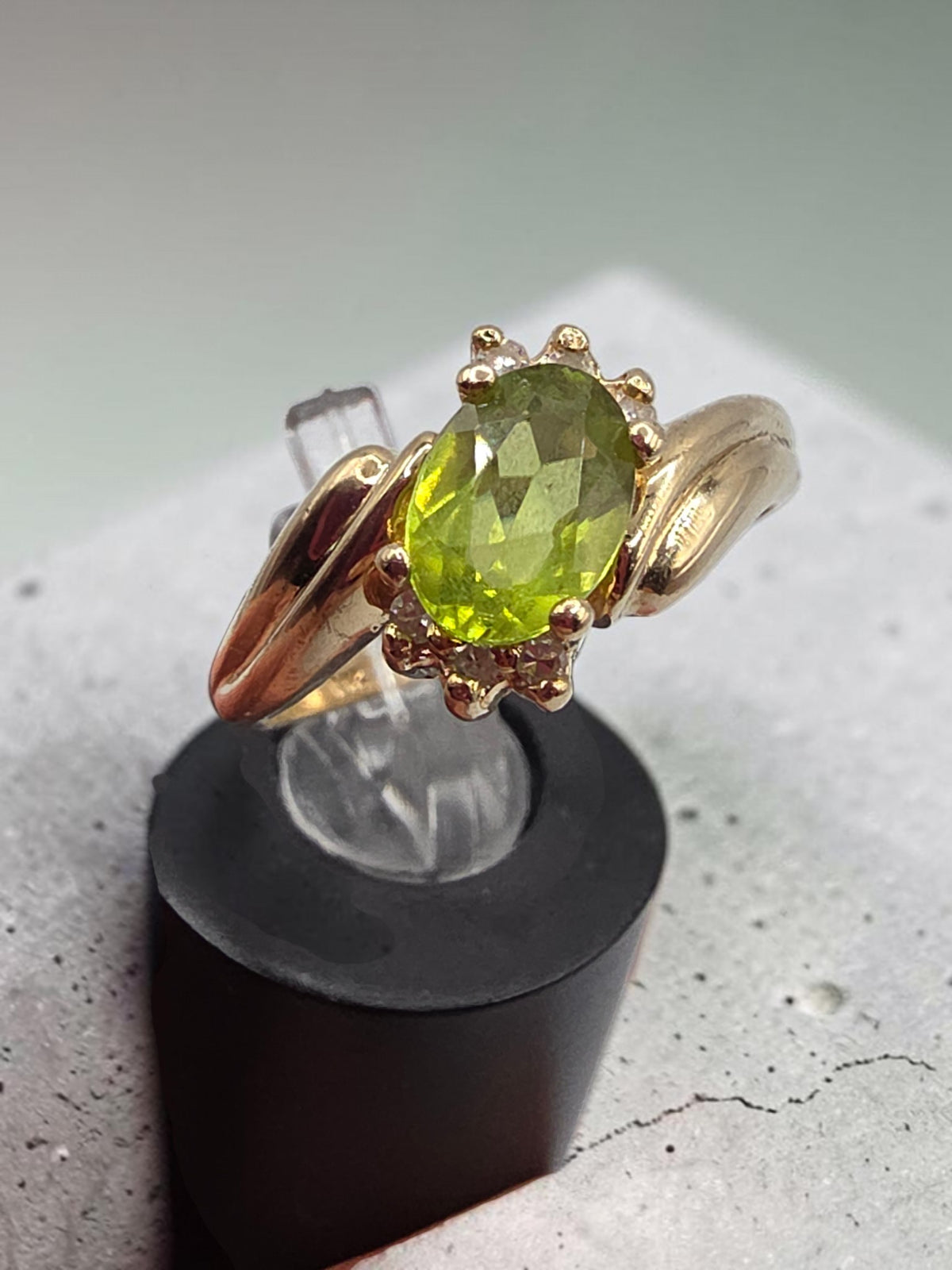 Solid 14K Yellow Gold Ring with Oval Cut Green Peridot Flanked by Arcs of Round Diamond Accents on Grooved Swept Shoulders