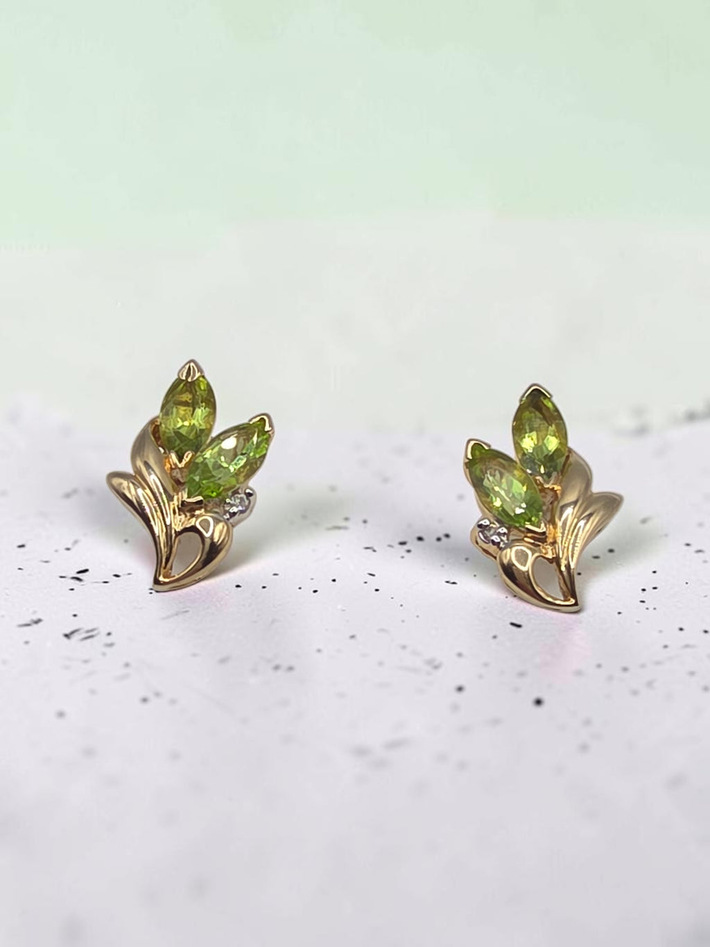 Solid 14K yellow gold marquise peridot floral stud earrings with diamond accents