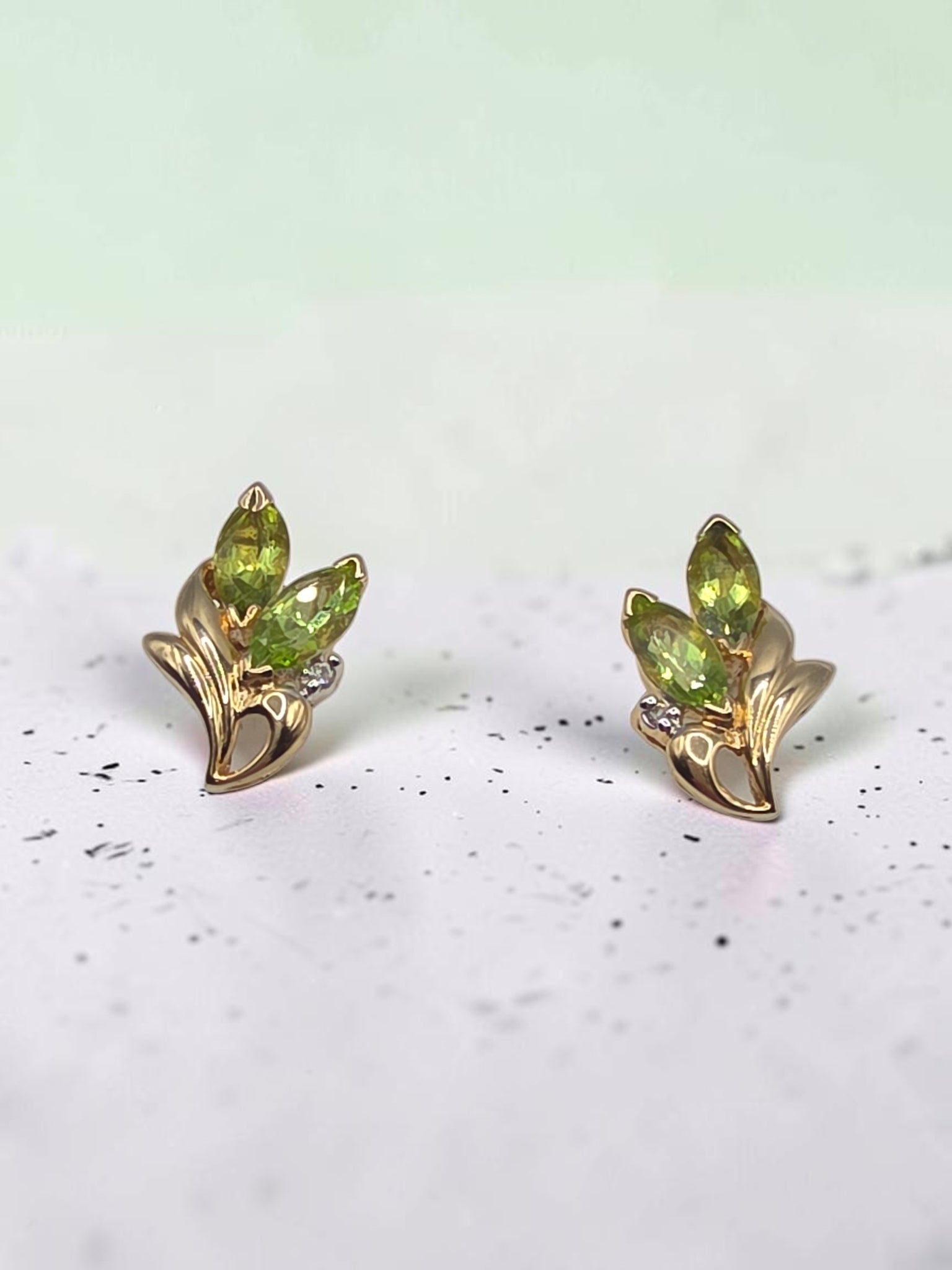 Solid 14K yellow gold marquise peridot floral stud earrings with diamond accents
