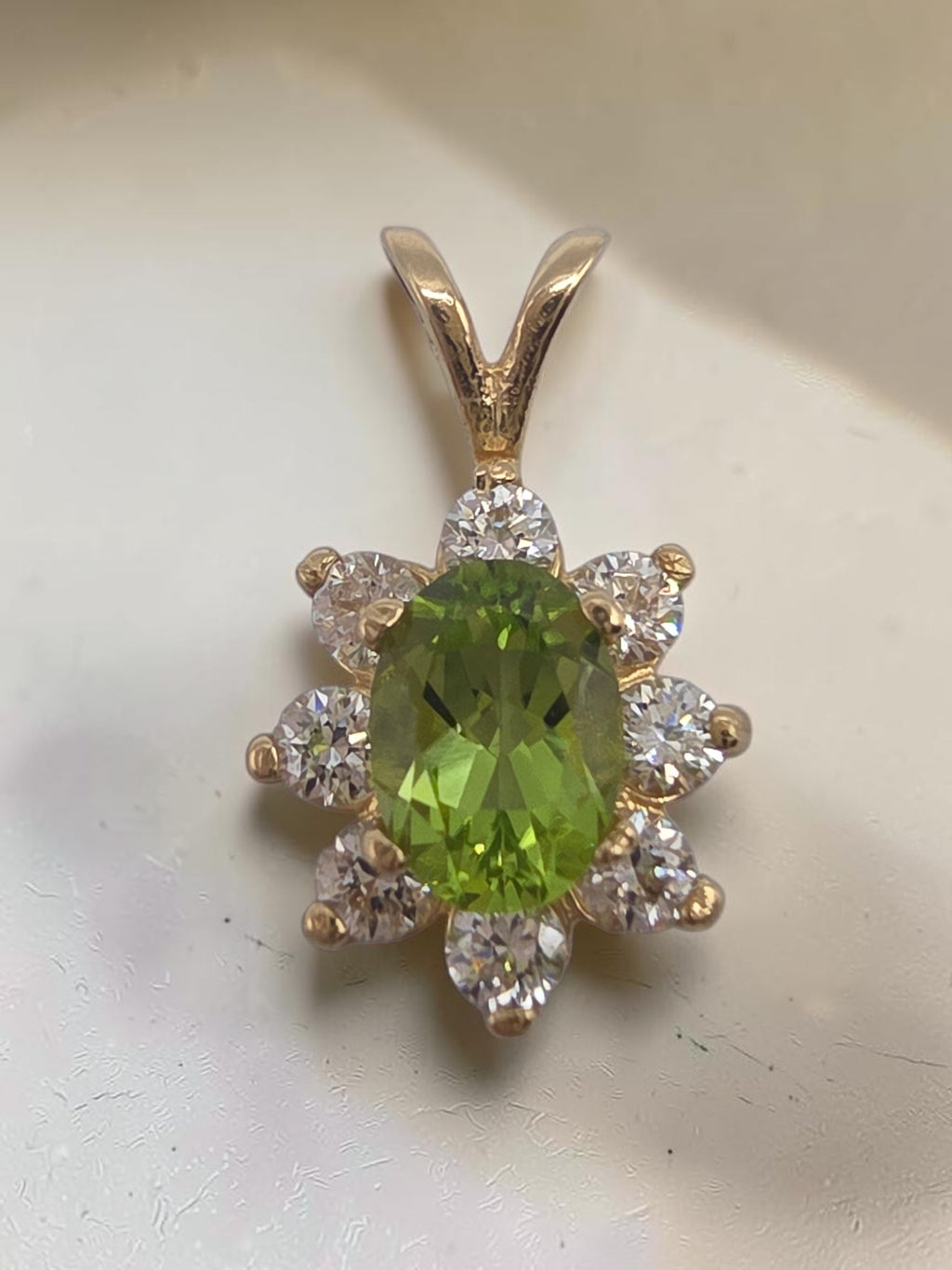 Solid 14K yellow gold oval peridot pendant with sparkling CZ halo flower design