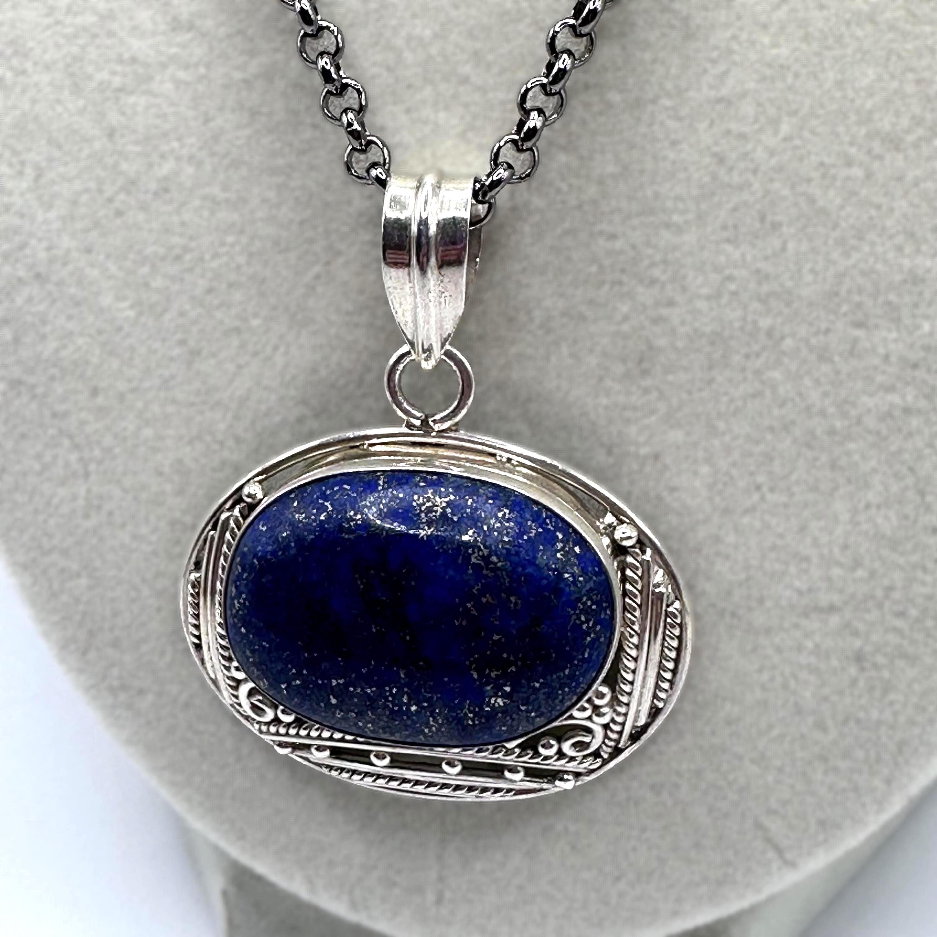 Sterling silver pendant necklace with a deep blue oval cabochon in an ornate beaded and rope twist frame on an 18 inch chain
