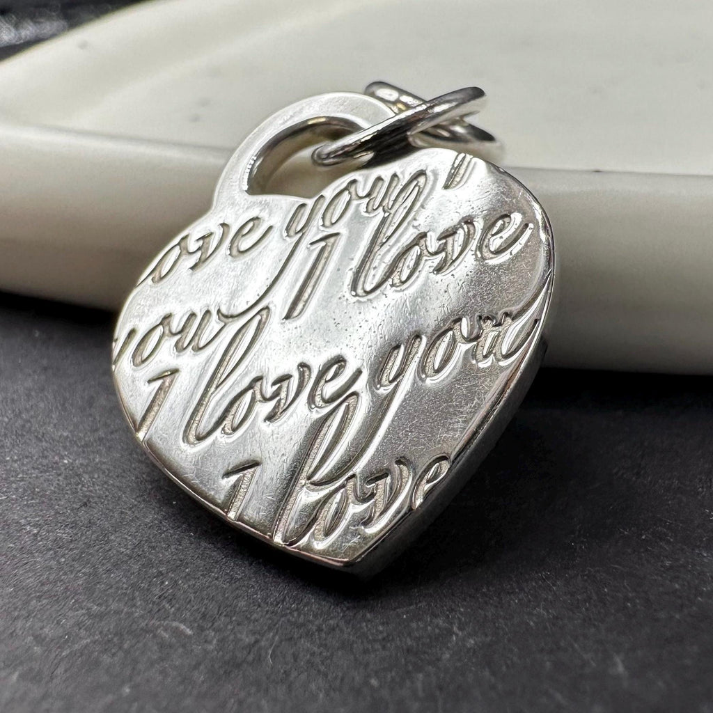 Tiffany & Co sterling silver heart charm pendant with repeating I Love You script, marked 925